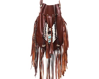 May include: A brown leather bucket bag with fringe detailing and a beaded and turquoise stone embellishment.
