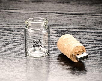 May include: A small glass bottle with a cork top USB drive. The bottle has the words "our story" written on it.