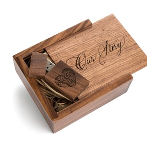 May include: A wooden box with a hinged lid, engraved with the words "Our Story". Inside the box is a wooden USB drive with a heart design and the words "Mr & Mrs" engraved on it.
