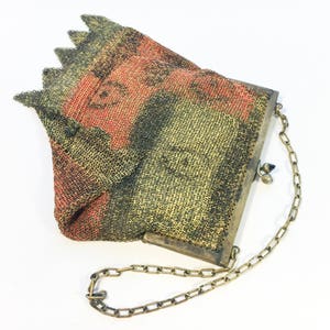 K&ouml;nnte beinhalten: Eine Vintage-Mesh-Handtasche mit einer Kettenkette. Die Tasche ist aus feinem Mesh-Material gefertigt und hat ein geometrisches Muster in Gr&uuml;n-, Schwarz- und Rott&ouml;nen. Die Tasche hat einen Metallverschluss und eine Kettenkette.
