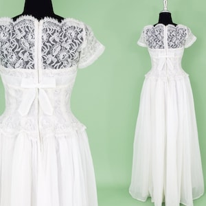 Puede incluir: Un vestido de novia blanco de encaje con un corpi&ntilde;o ajustado y una falda completa. El vestido tiene una superposici&oacute;n de encaje y un lazo en la espalda.