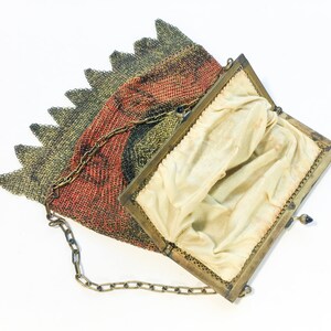 K&ouml;nnte beinhalten: Eine vintage goldene und rote Netz-Handtasche mit einer Kettenkette und einem Stofffutter. Die Tasche ist offen und das Futter ist sichtbar.