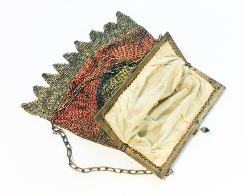 K&ouml;nnte beinhalten: Eine vintage goldene und rote Netz-Handtasche mit einer Kettenkette und einem Stofffutter. Die Tasche ist offen und das Futter ist sichtbar.