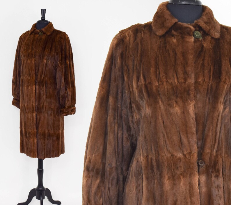 May include: A long brown fur coat with a collar and button closure.