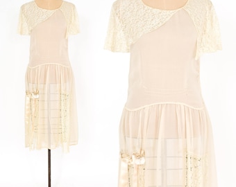 May include: A vintage ivory sheer dress with a lace overlay and a scalloped hem. The dress has a fitted bodice and a flowing skirt.
