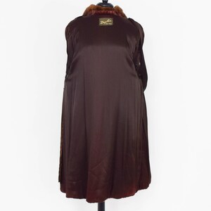May include: A brown fur coat with a brown satin lining. The coat has a label that reads "Dyfur Fine Furs".