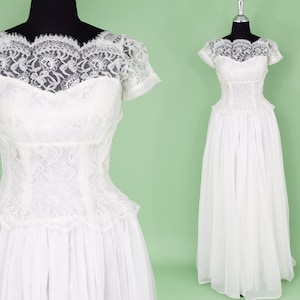 Puede incluir: Un vestido de novia vintage blanco con un corpi&ntilde;o de encaje y una falda completa. El vestido tiene mangas cortas y un escote redondo.