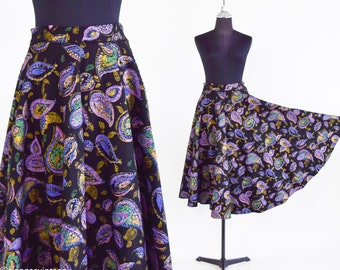 May include: A black skirt with a paisley pattern in shades of purple, gold, and green. The skirt is knee-length and has a flared silhouette.