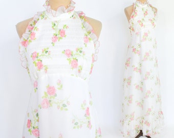 May include: A white maxi dress with a pink floral print and a ruffled halter neckline.