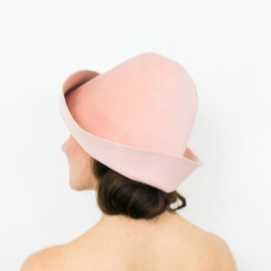 May include: A pink felt hat with a wide brim and a rounded crown.