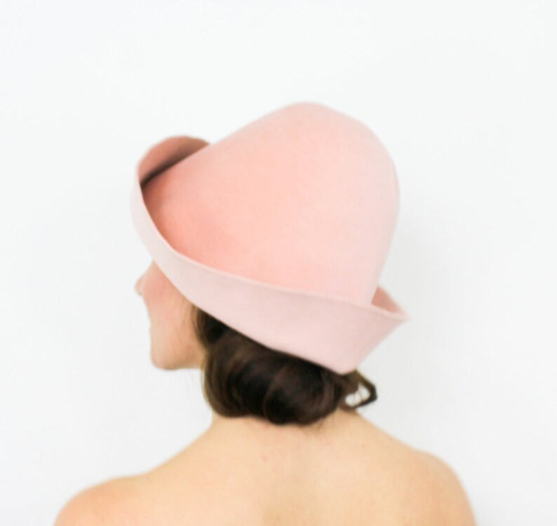 May include: A pink felt hat with a wide brim and a rounded crown.