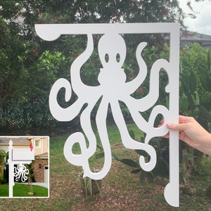 May include: White metal mailbox bracket shaped like an octopus with eight tentacles. The bracket is designed to be mounted on a post or wall.