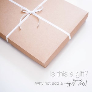 Puede incluir: Una caja de regalo de cart&oacute;n marr&oacute;n atada con una cinta blanca. La caja est&aacute; sobre una superficie blanca. El texto "Is this a gift? Why not add a gift box!" est&aacute; escrito debajo de la caja.