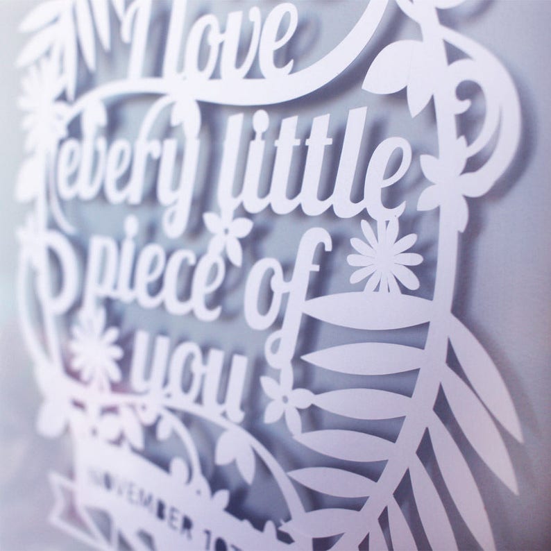 Puede incluir: Arte de papel recortado en blanco con el texto "Te amo cada pedacito de ti" y un dise&ntilde;o floral. El texto est&aacute; en una fuente decorativa.