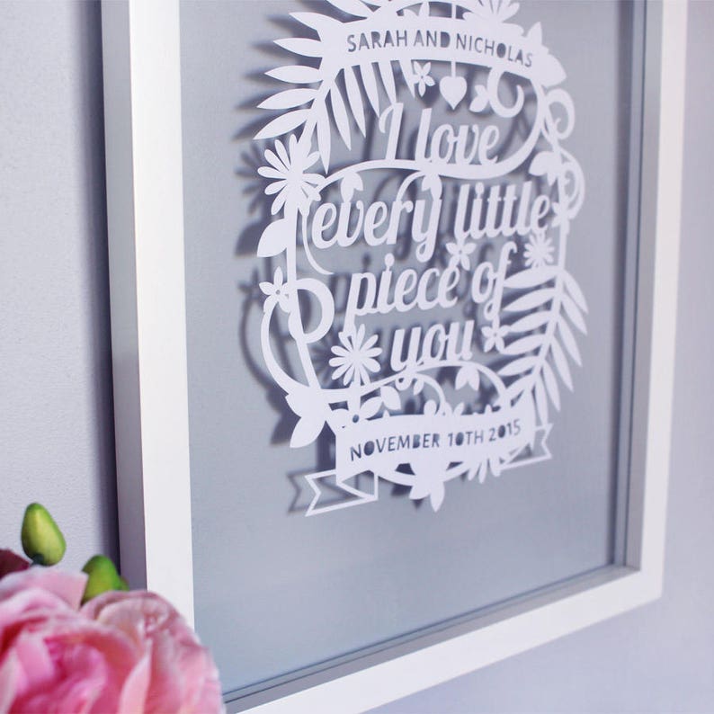 Puede incluir: Arte de papel recortado en blanco en un marco blanco. El arte presenta un dise&ntilde;o floral con las palabras "Te amo cada pedacito de ti" y la fecha "10 de noviembre de 2015".