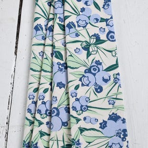 May include: Off-white kitchen towels with a repeating pattern of blueberries and leaves in shades of blue and green. The design features stylized blueberries and foliage, creating a fresh, botanical aesthetic.