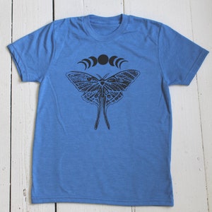 May include: A blue t-shirt with a black and white moth design and a crescent moon graphic.