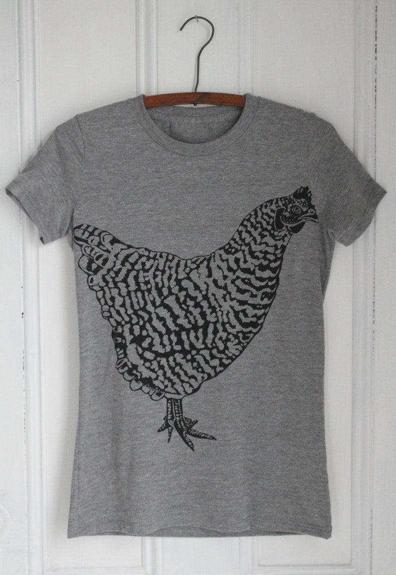 May include: A heather grey t-shirt with a black and white illustration of a chicken.