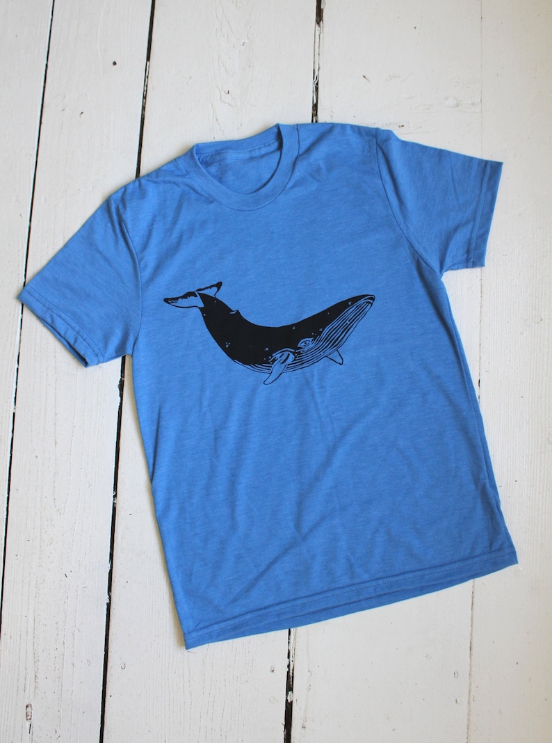 May include: A blue t-shirt with a black silhouette of a whale printed on the front.