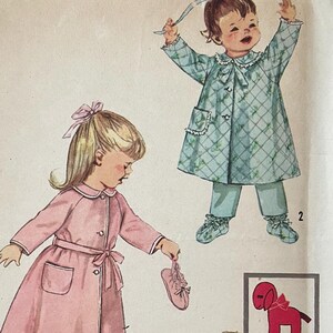 Peut inclure: Patron de couture Simplicity imprimé 40c, taille 2 pour enfant en bas âge. Le patron comprend trois tenues différentes : une robe rose avec un pantalon assorti, une robe matelassée bleue avec un pantalon assorti et une robe blanche avec une application de chien rouge. Le patron comprend également une illustration de chien rouge.