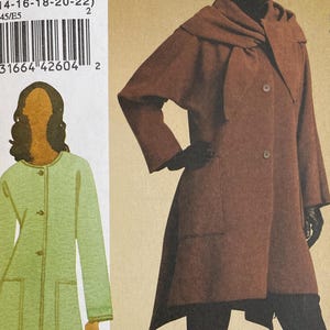 May include: A sewing pattern titled V8545, featuring illustrations of a long coat and a jacket. The pattern includes sizes 14-16-18-20-22. The Vogue Woman logo is visible at the bottom. The coat is brown, and the jacket is green.