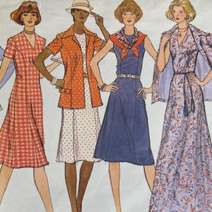 May include: Vintage Vogue's Basic Design sewing pattern featuring five illustrated women's fashion designs. The designs include dresses, jackets, and a cape, showcasing 1970s style. The pattern cover is in shades of blue, orange, and white.