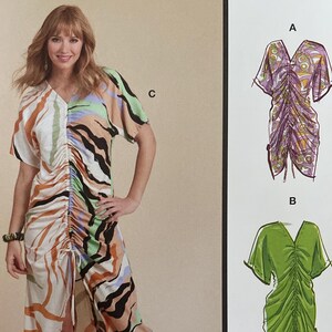 May include: McCall's sewing pattern showing a woman in a patterned dress. The pattern offers multiple view options. The dress has a V-neck and short sleeves. The pattern is designed and printed in the USA.