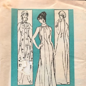 Peut inclure: Un patron de couture vintage pour une robe, avec trois illustrations d'une femme portant la robe. Le patron est imprimé sur un fond bleu clair avec le texte "Mr. Blackwell Printed Pattern Prominent Designer M304 - SIZE 8".