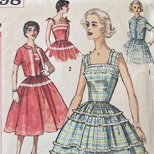 May include: Vintage Simplicity sewing pattern number 2498 for a dress with a plaid skirt and a ruffled bodice. The pattern is for size 11, bust 31 1/2 inches, and is printed on a white background with a red border.