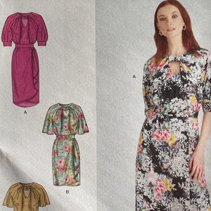 May include: Simplicity sewing pattern S9677. The pattern features three dress designs, including a midi dress with a floral print. The pattern includes sizes 6-14. The American Sewing Guild designed and printed the pattern in the USA.