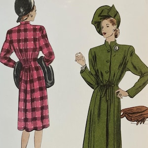 May include: Vogue Patterns sewing pattern featuring two vintage dress designs. The pattern includes a pink and black plaid dress and a green dress with a matching hat. The pattern is a reissue from 1945 and is designed and printed in the USA.