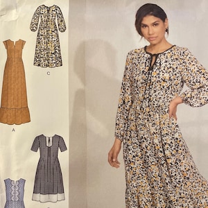 May include: Simplicity sewing pattern S8872 D5 featuring a woman wearing a floral print dress. The pattern includes multiple dress designs, with size information for U.S. sizes 4-12. The Simplicity logo and "Since 1927" are also visible.