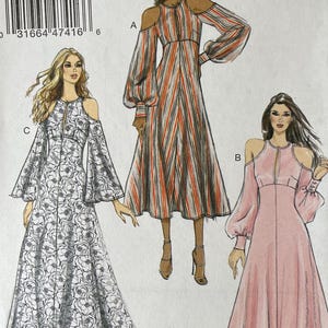 May include: Vogue Patterns sewing pattern envelope showing illustrations of three dresses with cold-shoulder sleeves. The dresses are in different colours and patterns. The envelope includes the pattern number V9296 and size range E5.
