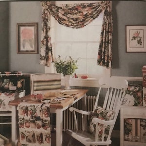 May include: McCall's Creative Decor sewing pattern number 8391. The pattern includes instructions for making a window valance, table runner, and pillow. The image shows a room with a window, table, and chair, all decorated with the finished projects. The fabric features a floral pattern with fruits and vegetables.