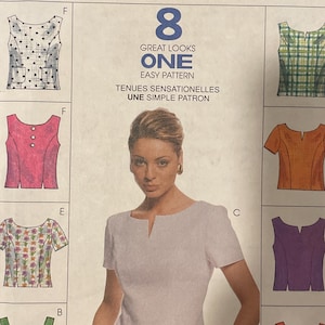 May include: A McCall's sewing pattern featuring eight different top designs. The pattern includes illustrations of various tops in different colors and styles, with the text "GREAT LOOKS ONE EASY PATTERN". The pattern size is B (8, 10, 12).