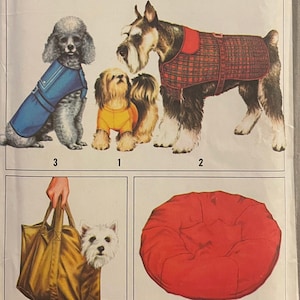 May include: Simplicity sewing pattern number 8802 for making dog clothes and accessories. The pattern includes instructions for making a red and black plaid dog coat, a blue dog coat, a yellow dog sweater, a brown dog carrier bag, and a red dog bed.
