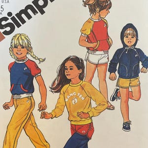 May include: A vintage Simplicity sewing pattern for girls' sportswear, featuring illustrations of children in various outfits. The pattern includes designs for sweatshirts, shorts, and trousers. The Hang Ten logo is visible. Sized for stretch knits.