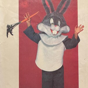 May include: Vintage Butterick sewing pattern for a Bugs Bunny costume. The pattern features a full-body Bugs Bunny costume with a carrot accessory. The envelope is white with red and black text, and the Warner Bros. logo is visible.