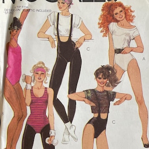 May include: A McCall's 9102 sewing pattern envelope featuring illustrations of five figures wearing various athletic leotards, leggings, and tops. The white paper envelope includes the text McCall's, 9102, and Brooke Shields branding, with a barcode and pricing information printed on the front.