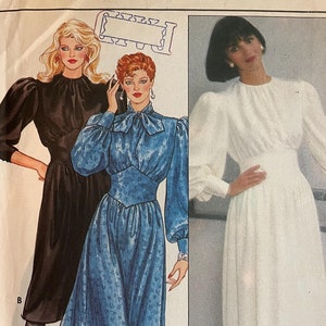 May include: A vintage sewing pattern for a dress with three different styles. The pattern is for size 8 and features a white dress with a high neckline and long sleeves, a blue dress with a bow at the neckline and long sleeves, and a black dress with a high neckline and long sleeves.