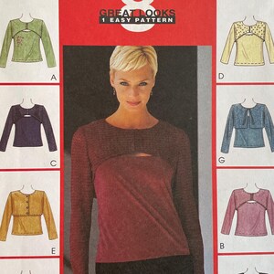 May include: McCall's sewing pattern number 2886 for a women's top with a keyhole neckline. The pattern includes eight different variations of the top, including a long-sleeved top with a keyhole neckline, a short-sleeved top with a keyhole neckline, and a sleeveless top with a keyhole neckline. The pattern is for sizes 8-10.
