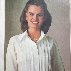 May include: Vintage Simplicity sewing pattern, number 8186, featuring a woman wearing a white collared shirt. The pattern is labeled "ESP Extra-Sure Pattern" and includes sizes 14, 16, and 18. The price is 95 cents.