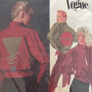 May include: Vogue sewing pattern showing a red jacket design with a geometric shape on the back. The pattern includes illustrations of the jacket and the text "CHRISTIAN AUJARD" and "Vogue".