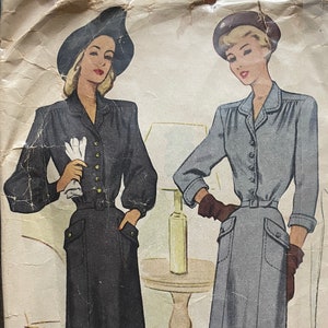 May include: Vintage McCall's sewing pattern for a dress, size 12, bust 32. The pattern features two illustrations of women wearing the dress, one in black and one in gray. The pattern is labeled "Ladies' & Misses' Dress" and "6999".