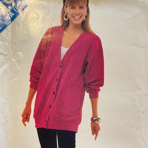 May include: A Butterick 5822 sewing pattern featuring a woman in a pink cardigan with a geometric pattern, black leggings, and a white top. The text "VERY EASY / TRÈS FACILE" is visible. The pattern is described as 'very easy'.
