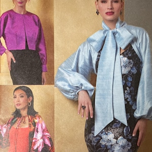 May include: Vogue Patterns R12222 sewing pattern. The pattern features three different designs, including a cropped jacket in purple, a light blue jacket with a bow, and a floral-sleeved jacket. Size A (XS-S-M-L-XL). Designed and printed in the USA.