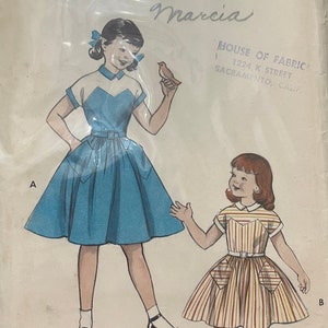 Peut inclure: Patron de couture vintage pour une robe de fille. Le patron est pour une robe bleue avec un col blanc et une robe à rayures rouges et blanches avec des poches. Le patron est de Butterick et est de taille 10, tour de poitrine 28. Le patron s'appelle "Marcia".