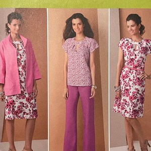 May include: Simplicity sewing pattern number 1885 BB for sizes 20W-28W. The pattern includes instructions for making a dress, top, pants, and jacket. The dress and top have a floral print with a pink background. The pants and jacket are solid pink. The pattern is shown on three models.
