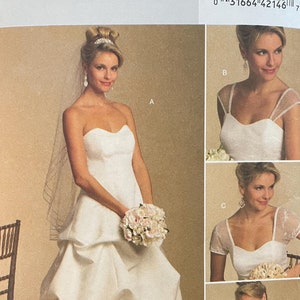 May include: A wedding dress pattern with a strapless bodice and a full skirt. The pattern includes four different sleeve options: sleeveless, cap sleeves, short sleeves, and long sleeves. The pattern is for sizes 8-10-12-14.