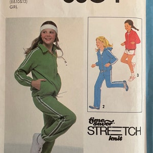 May include: Simplicity sewing pattern number 8804 for a girl's tracksuit. The pattern includes instructions for sizes 8, 10, and 12. The pattern is for stretch knit fabric. The pattern cover features a line drawing of a girl wearing the tracksuit.